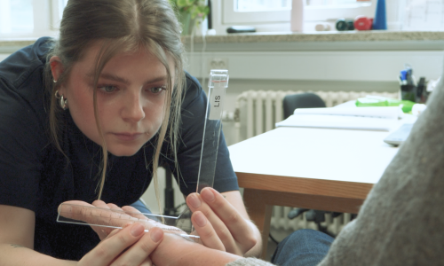 Portræt af Julie, der sidder og laver målinger på en borgers hånd